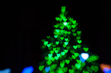 beautiful green bokeh in form of Christmas tree on black background