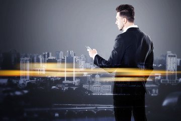 Fototapeta premium Businessman with smartphone and orange city