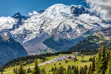 View of Sunrise lodge while hiking with the impressive Mount Rainier in the background on a sunny...