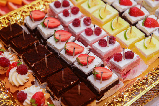 Delicious mini cakes with lemon, strawberry and rasberry