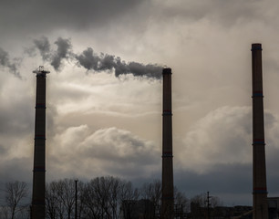 Air pollution from coal-powered plant smoke stacks, and industrial cityscape, on a gloomy, overcast day