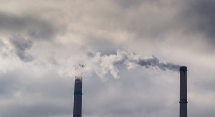 Air pollution from coal-powered plant smoke stacks, and industrial cityscape, on a gloomy, overcast day