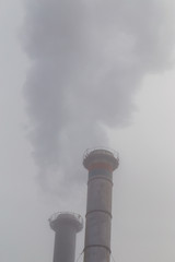 Air pollution from coal-powered plant smoke stacks, and industrial cityscape, on a gloomy, overcast day