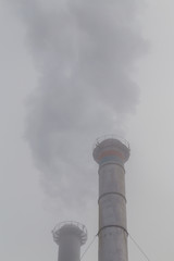 Air pollution from coal-powered plant smoke stacks, and industrial cityscape, on a gloomy, overcast day