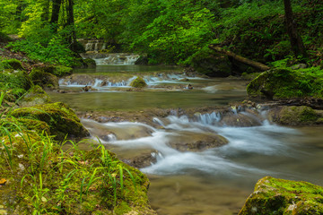 Pristine waterfalls deep in the woods, on a bright sunny day in spring