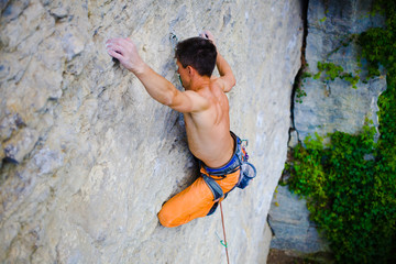 Male sports and climbs on the rock.