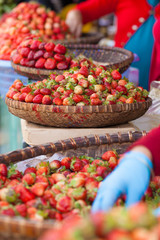 Fototapeta na wymiar Lots of fresh red strawberry put in local style weave basket selling in fresh market, Vietnam