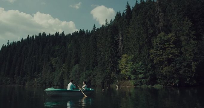 Couple rowing on  beautiful lake,they Happy romantic moments and enjoying time on lake in slow motion 4k.