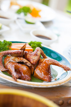 A dish of Nice oily brown color of Fried pigeon put on a nice decorated plate in Cantonese restaurant in Vietnam