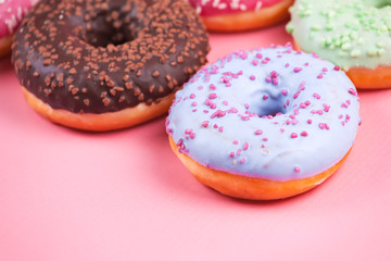 Sweet colorful tasty donuts on pink background.