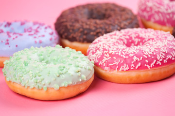 Sweet colorful tasty donuts on pink background.