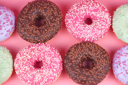 Sweet colorful tasty donuts on pink background.