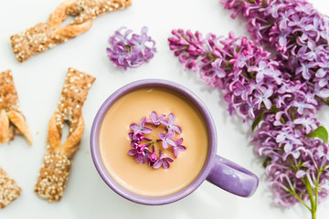 Spring lilac flowers with mug of coffee