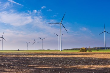 Spring or autumnal landscape with windmills on fields