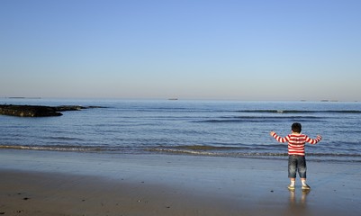 Fototapeta na wymiar garçon au bord de la mer sur les plages de Normandie 14 Calvados