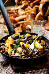 fried potato with mushrooms in a vintage frying pan