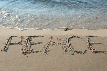 Peace written in the sand on the beach