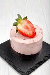 Creamy strawberry cake on stone background