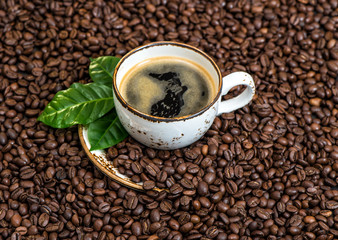 Black coffee with green leaves caffee beans background