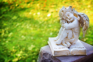 Engel mit Buch auf Grabstein
