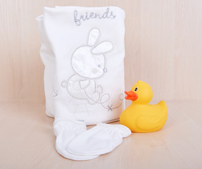 Children's clothing diapers pajamas mittens socks vests sliders white background and ruber toy yellow duck - Powered by Adobe