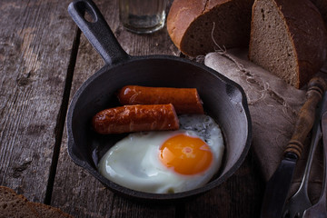 Fried eggs with sausages in a pan
