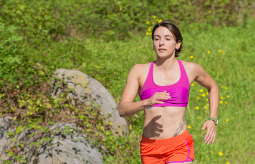 Beautiful athletic woman running in countryside