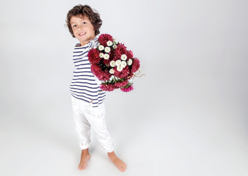 Cute and funny little boyin stripe shirt with flowers over white