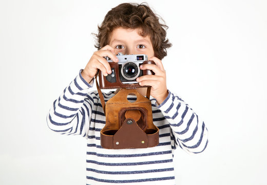 Cute and funny little boy with old film camera over white 