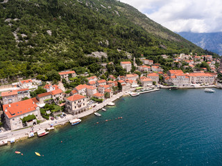 Perast town lies beneath the hill of St. Ilija. Aerial view of shore. Adriatic sea. Kotor bay (Boka Kotorska), Montenegro