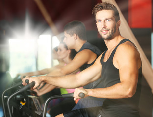 Obraz premium People training on exercise bike in gym