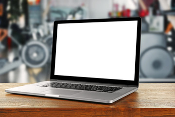 Laptop with blank screen on blurred gym background
