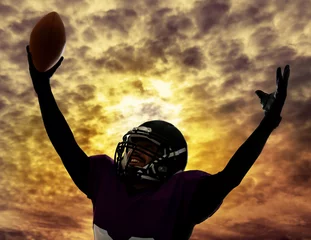Foto op Canvas American football player silhouette on sky with clouds background © Africa Studio
