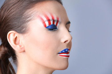 Girl with USA makeup on grey background