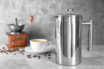 New coffee maker, grinder and cup of fresh drink on table