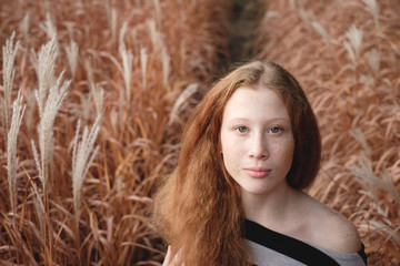 Tender girl feels freedom on the autumn field.