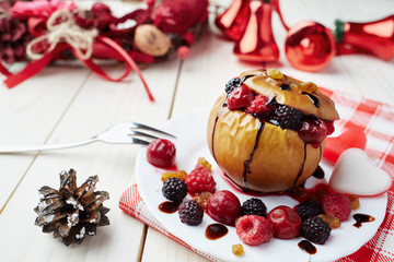 Baked apple with berries and chocolate sauce. Wooden background. Healthy lifestyle.Diet and weight loss concept. Low calories dinner. Vitamin B. Healthy food.