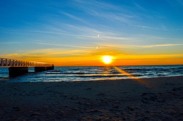 Naklejka premium Brilliant sunrise over the waters of Lake Huron in Oscoda, Michigan
