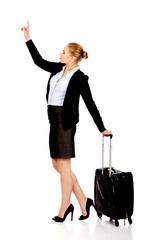 Business woman carrying a suitcase and looking up