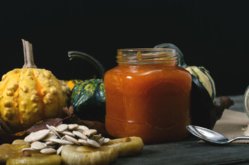 Dried figs, pumpkin seeds, pumpkins and pumpkin jam on vintage table. Selective focus and small depth of field.