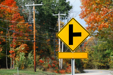 T intersection ahead sign with colorful fall forest 