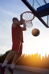 Young man jumping and making a fantastic slam dunk playing stree © FS-Stock