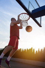 Young man jumping and making a fantastic slam dunk playing stree © FS-Stock