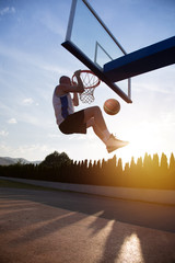 Young man jumping and making a fantastic slam dunk playing stree © FS-Stock