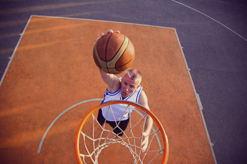 Basketball street player making a slam dunk
