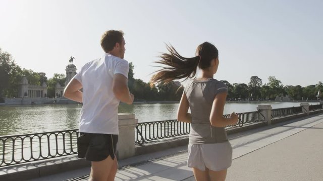 Jogging runners jogging running in Madrid El Retiro city park. Exercising woman and man runner training on jog living healthy lifestyle in Buen Retiro Park, Parque el Retiro in Madrid, Spain, Europe.