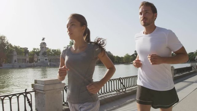 Sport runners jogging running in Madrid El Retiro city park. Exercising woman and man runner training on jog living healthy lifestyle in Buen Retiro Park, Parque el Retiro in Madrid, Spain, Europe.