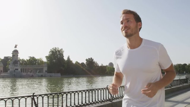 Running jogging man in city park El Retiro Madrid. Male runner exercising and training on run living healthy active lifestyle in Buen Retiro Park, Parque el Retiro in Madrid, Spain, Europe.