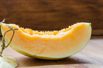 Fresh sliced cantaloupe on wooden background