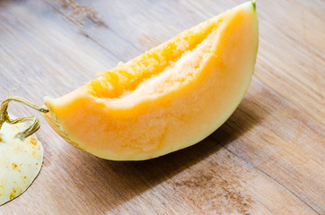 Fresh sliced cantaloupe on wooden background